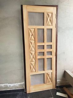 a wooden door sitting next to a window on top of a tiled floor in front of a wall