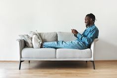 a man sitting on top of a white couch