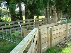 the fence is made out of wood and has metal bars on each side, along with some grass