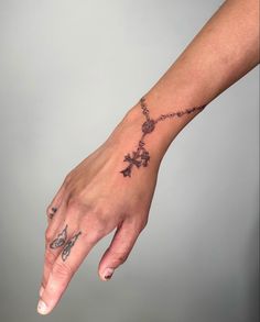 a person's hand with a cross tattoo on it