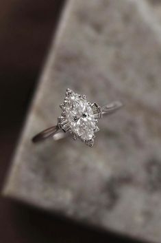 a diamond ring sitting on top of a marble slab