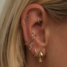 a woman wearing three different ear piercings