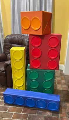 a stack of lego blocks sitting on top of a floor next to a brown chair