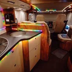 the inside of an rv with lights on and sink in it's center area