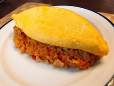 an omelet with meat and rice on a plate