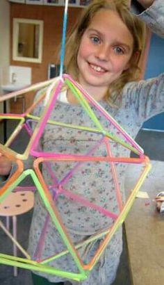 a woman holding up a kite made out of string