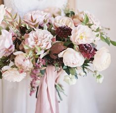 a bride holding a bouquet of flowers in her hands