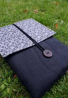 an ipad case sitting in the grass with a button on it's side,