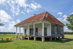 an old house sits in the middle of a field