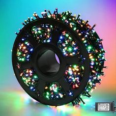 a spool of christmas lights sitting on top of a rainbow colored background with the words,