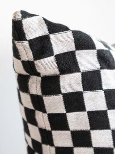 a black and white checkered pillow sitting on top of a chair