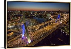 an aerial view of a city at night with traffic on the road and bridge in the foreground