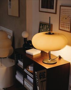 a lamp sitting on top of a wooden table next to a book shelf filled with books