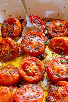 tomatoes in a casserole dish with a spoon resting on the top and side