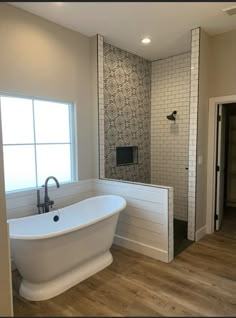 a large white bath tub sitting next to a window