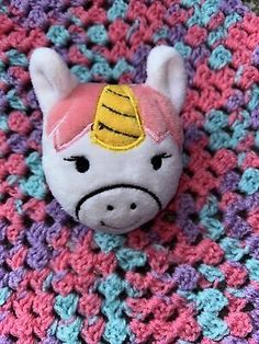 a small stuffed animal on top of a crocheted blanket in the shape of a pony