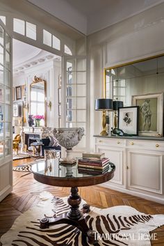 a living room filled with furniture and a zebra rug on top of a hard wood floor