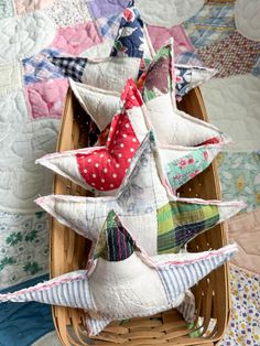 several pillows in a basket on a quilted surface