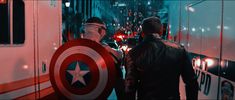 two men in captain america costumes standing next to an ambulance