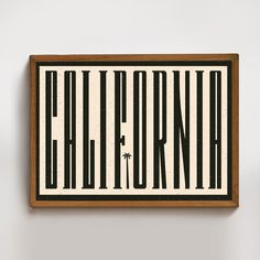 a black and white sign with the word california on it's side in front of a wall