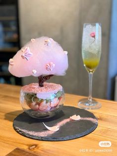 a small mushroom sitting on top of a plate next to a glass filled with liquid