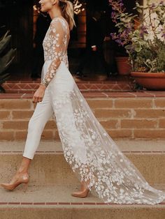 the woman is walking down the steps in her wedding dress