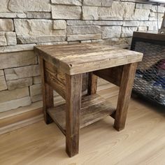 a wooden table sitting on top of a hard wood floor next to a brick wall