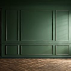 an empty room with green walls and parquet flooring in the center is shown