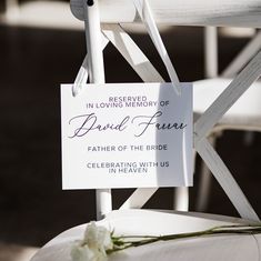 a close up of a white chair with a sign attached to the back of it