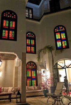 the inside of a building with stained glass windows and couches in front of it