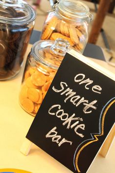 a sign that says one smart cookie bar next to some jars with cookies in them