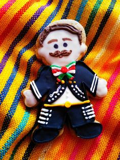 a close up of a small toy on a colorful cloth with a man in uniform