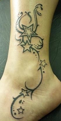 a tattoo on the foot of a woman with stars and crescents around her ankles