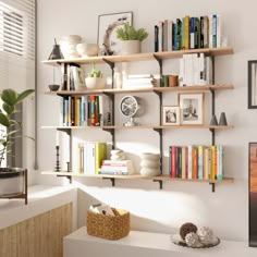 there is a shelf with many books on it in the living room, along with other items