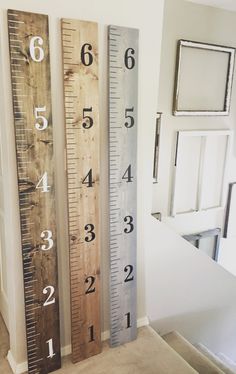 three wooden rulers with numbers on them in front of a door and window sill