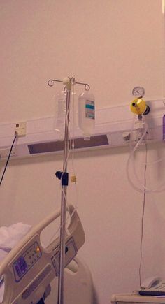 a hospital room with an iv and monitor on the wall, next to a bed