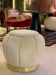 a white ottoman sitting on top of a floor next to a table with chairs around it