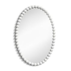 a white round mirror with beads around it