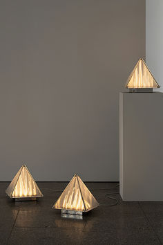 three lamps sitting on top of a floor next to a white box with lights in it