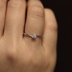 a woman's hand with a diamond ring on it