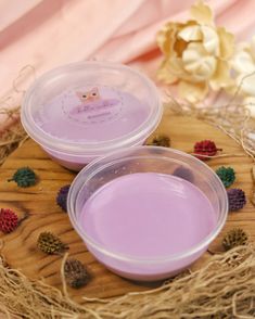 two plastic bowls sitting on top of a wooden tray