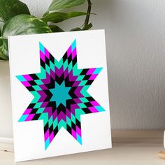 a colorful star design on a white background art boarder next to a potted plant