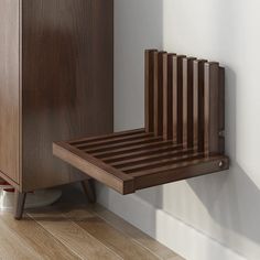 a wooden chair sitting on top of a hard wood floor next to a white wall