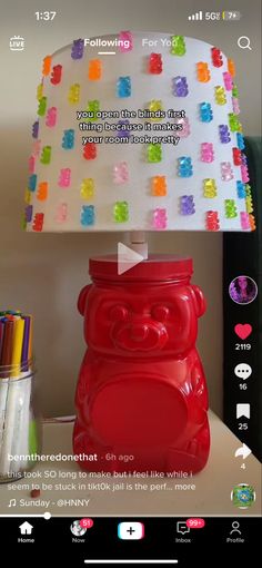 a red lamp sitting on top of a table next to a cup and pen holder