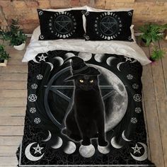 a black cat sitting on top of a bed next to a white moon and pentagram