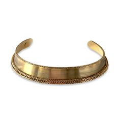 a gold cuff bracelet on a white background