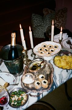 a table topped with lots of food and candles