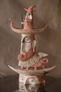 a ceramic sculpture of a man with a hat on his head and holding a pipe