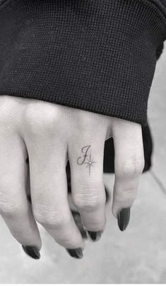 a person's hand with a small tattoo on it