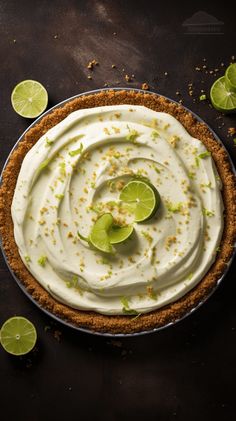 a pie with limes and whipped cream on top, surrounded by sliced limes